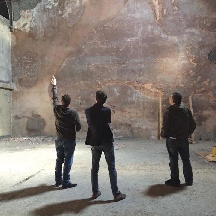 Image of 3 people looking at a wall inside the Ramsbottom Co-op hall theatre